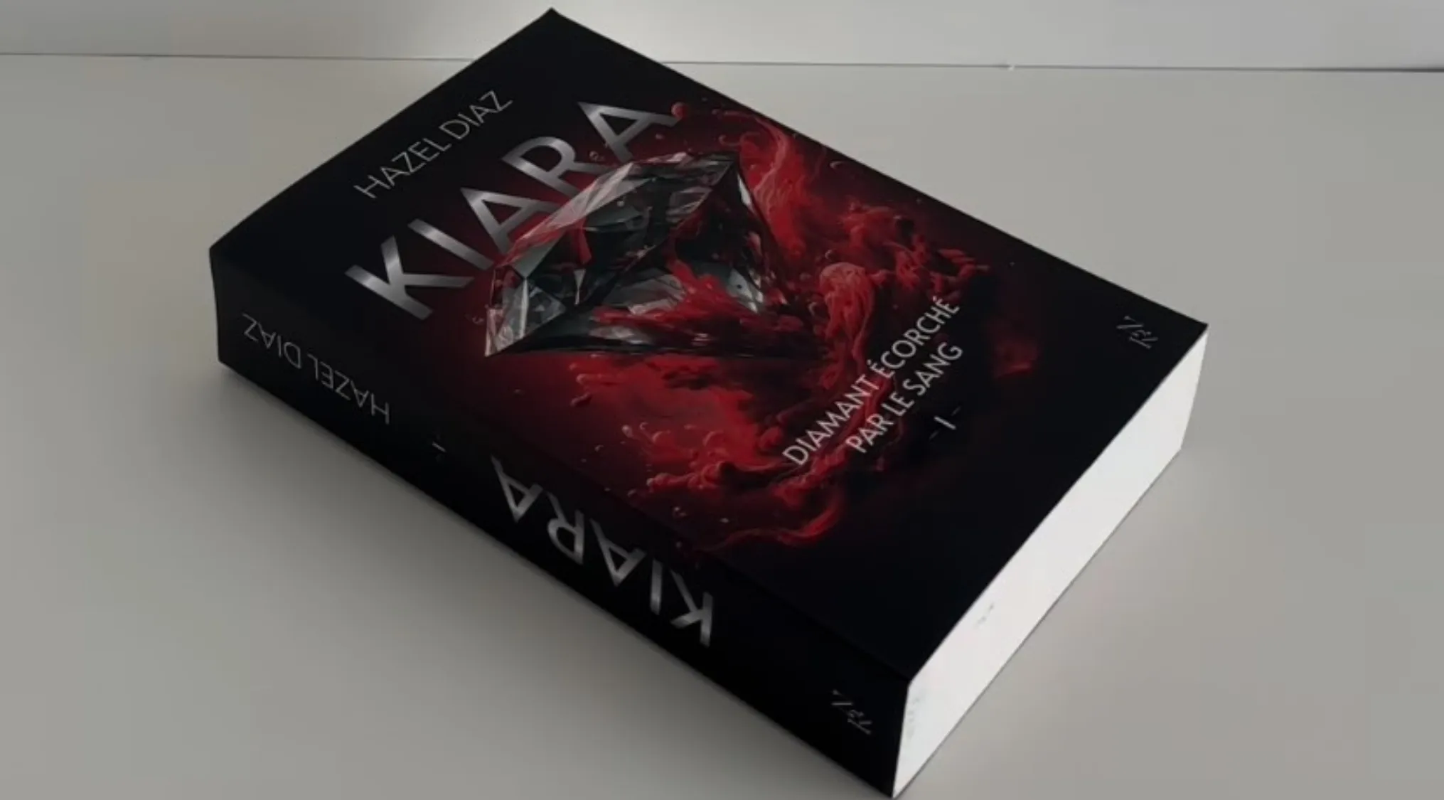 Book with black cover and red design featuring a diamond, questioning if it is real or a sliceable cake.