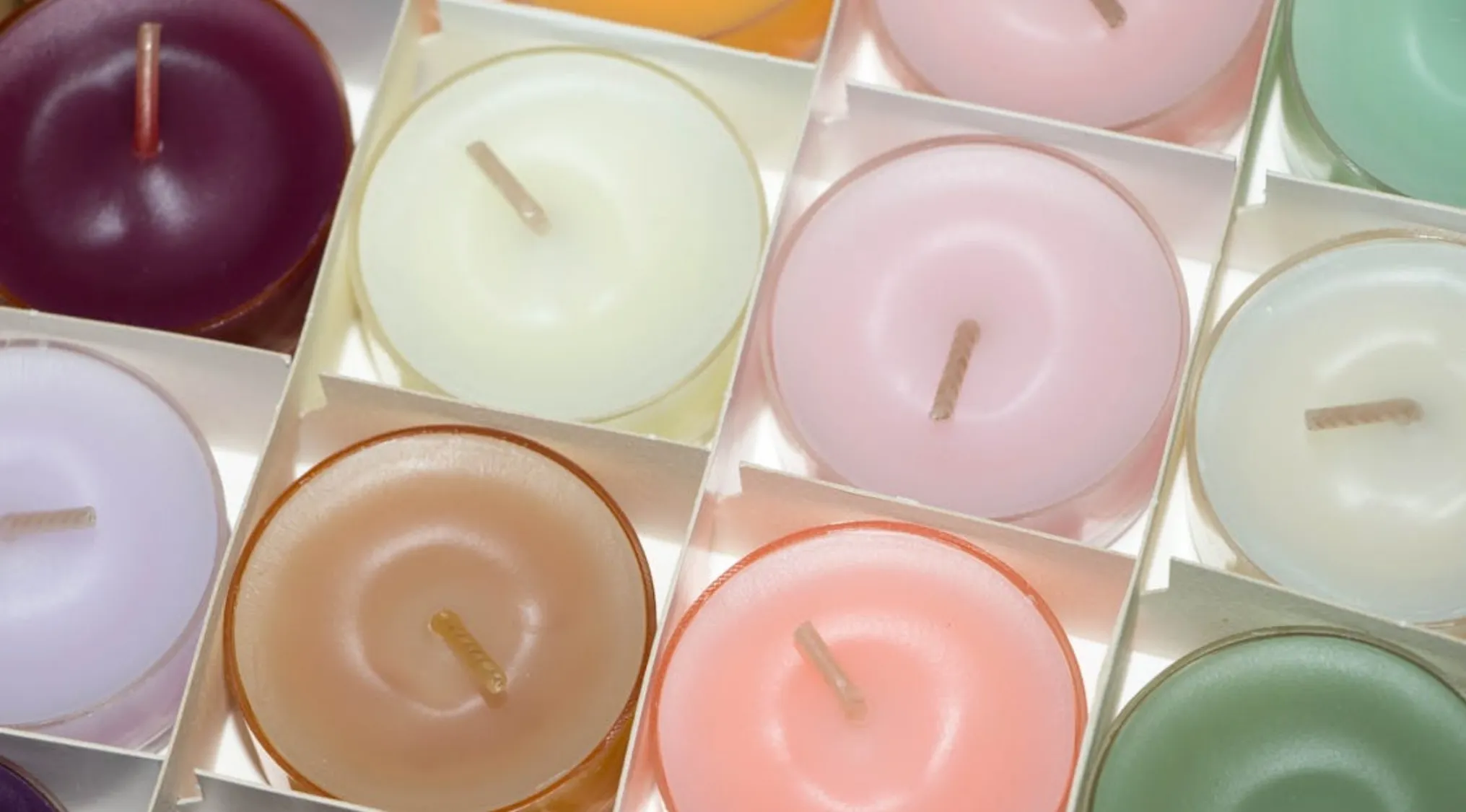 Close-up of colorful candles with wicks, raising the question if they are real candles or pretty little cakes.