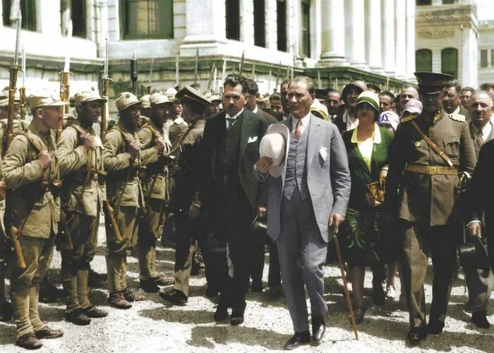 Historic site photo showing a group of soldiers and civilians gathered outside a grand building, capturing history repeated.