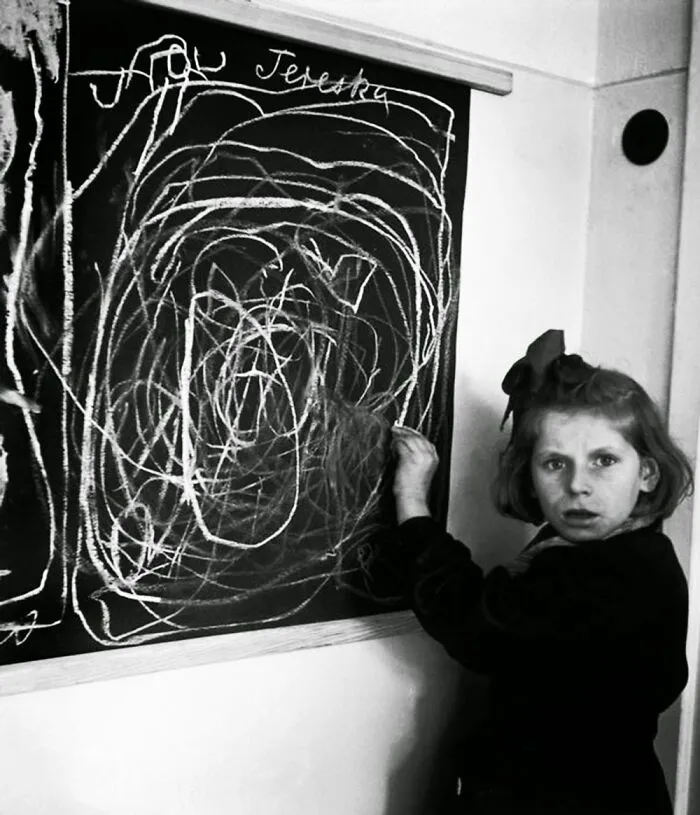 Young girl drawing on a chalkboard at a historic site, showcasing fascinating history repeated through past education.