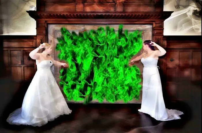 Two brides in wedding dresses pretending to cast spells with green flames in an awkward wedding photo.