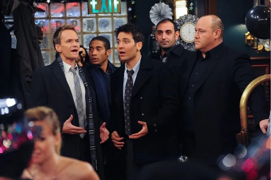 Main cast of How I Met Your Mother in MacLaren's bar, engaged in conversation during a scene from the sitcom.