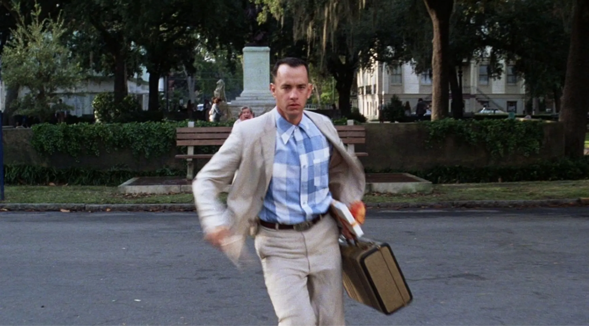 Man running across street holding a suitcase and book, related to trivia night and naming this character quiz.