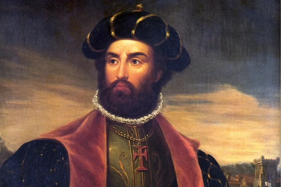 Portrait of European explorer Vasco da Gama wearing a black hat and ornate clothing against a sunset background