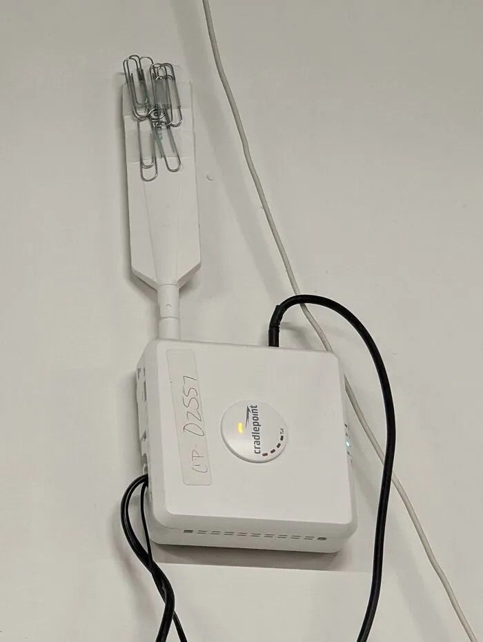 WiFi router with a makeshift antenna using paper clips attached to improve signal strength in a creative example.