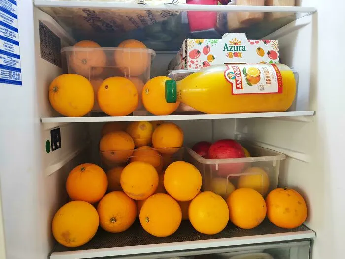 Oranges and juice bottle inside a fridge with other food items, highlighting surprising fridge contents found by people online