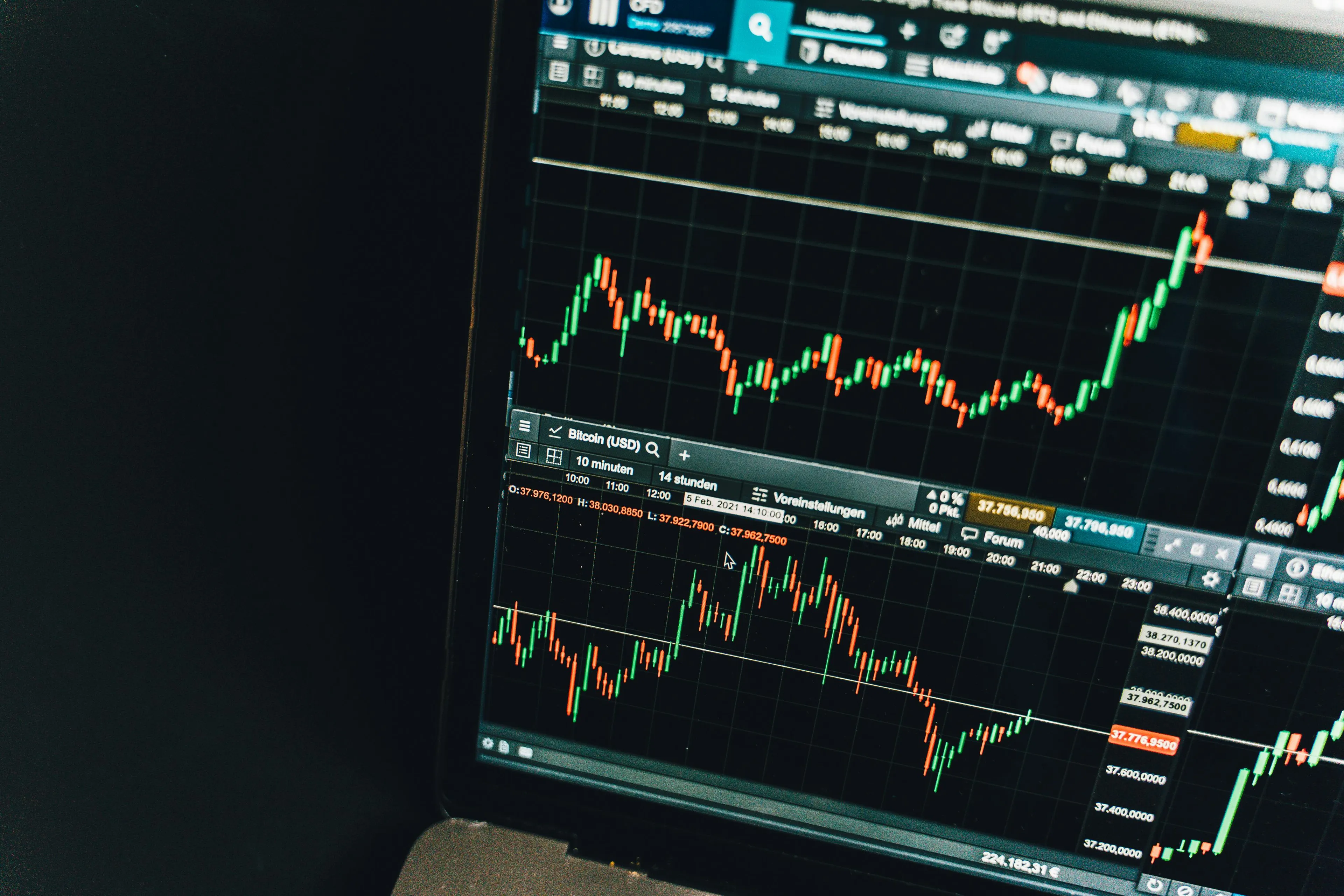 Close-up of a laptop screen showing financial charts with wave properties measured in hertz frequency indicators.