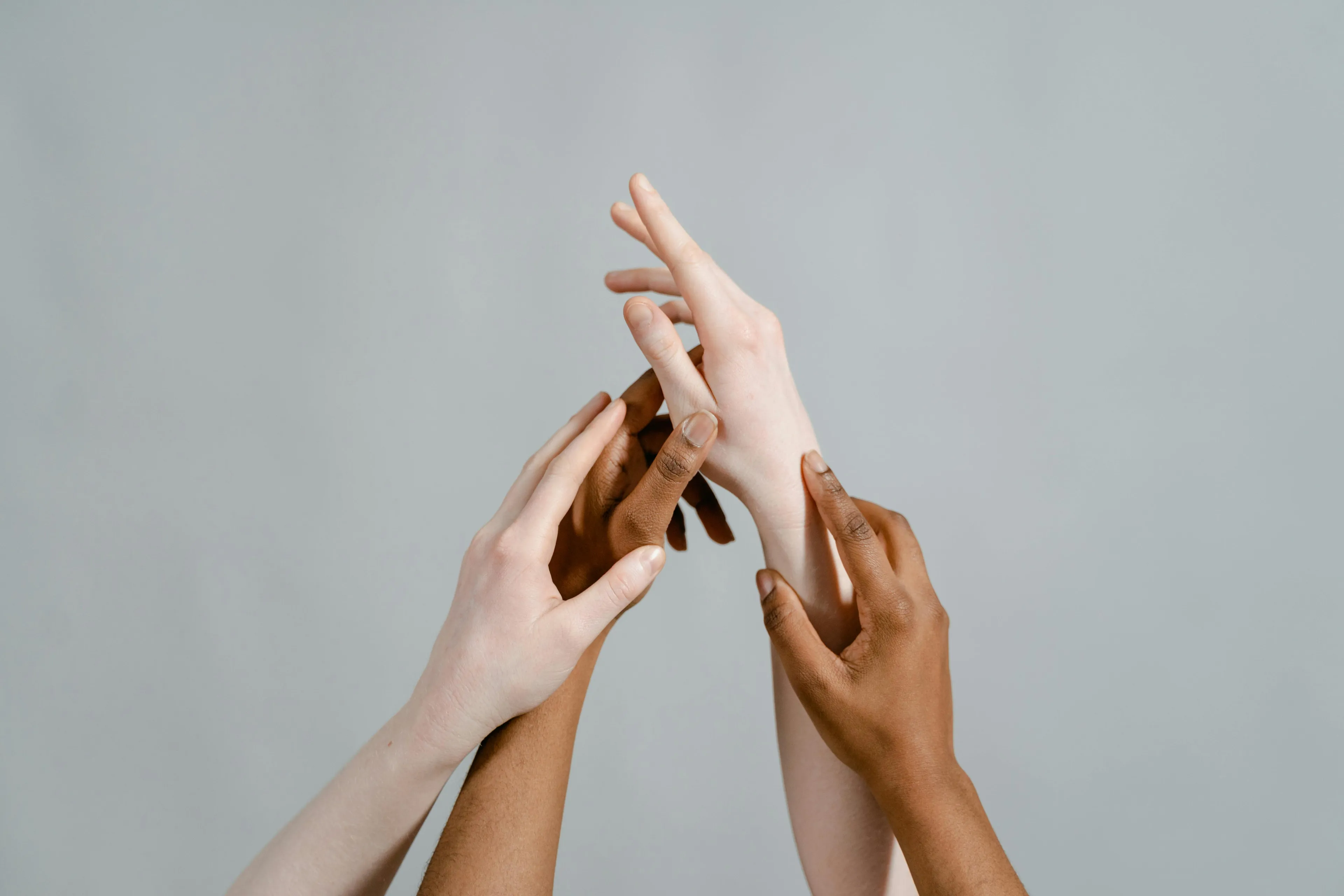 Multiple hands with varied skin tones gently touching each other symbolizing connection and the biological molecule storing genetic information