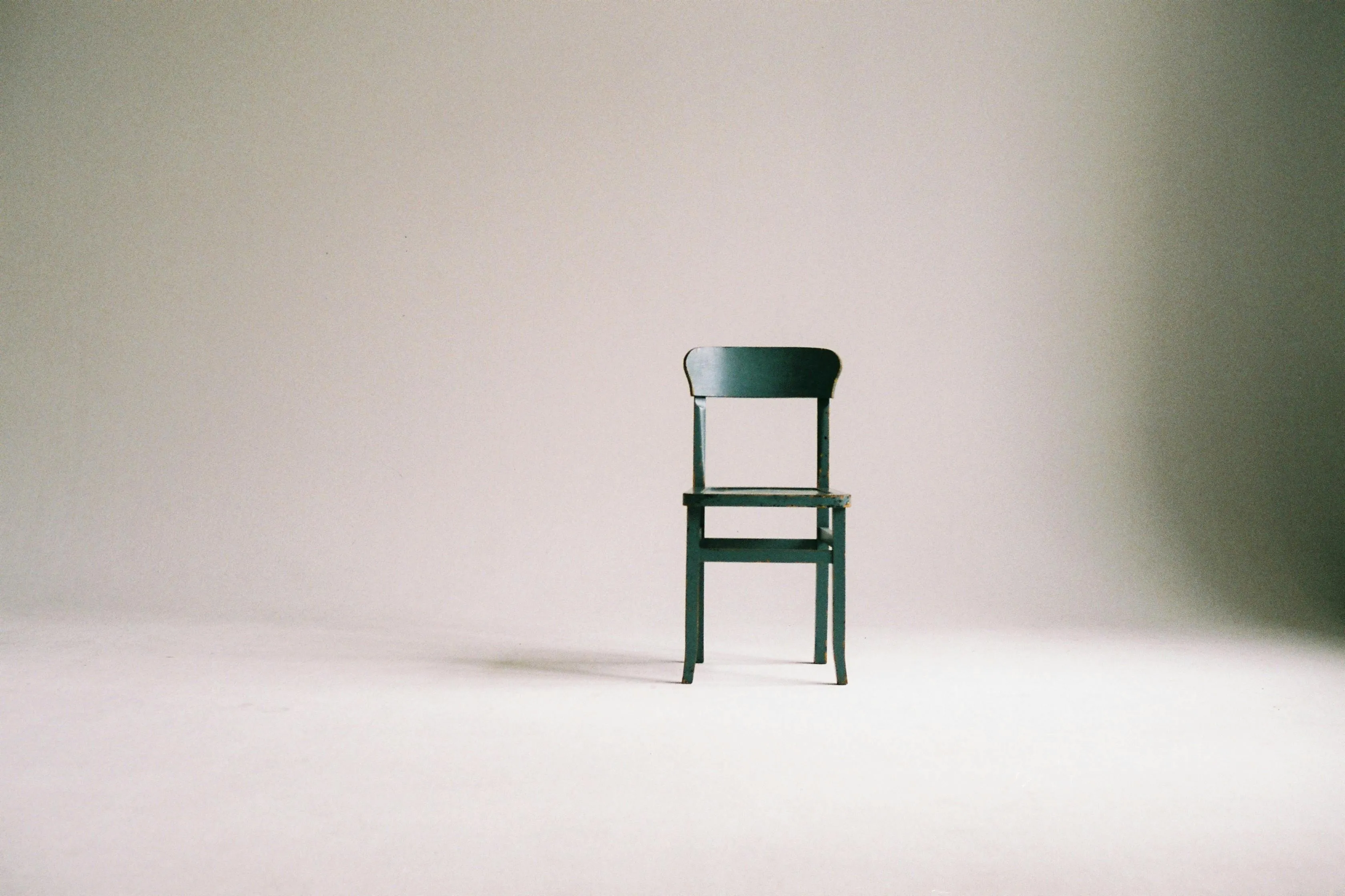 Old wooden chair standing alone in an empty space, symbolizing the science general knowledge principle of inertia.
