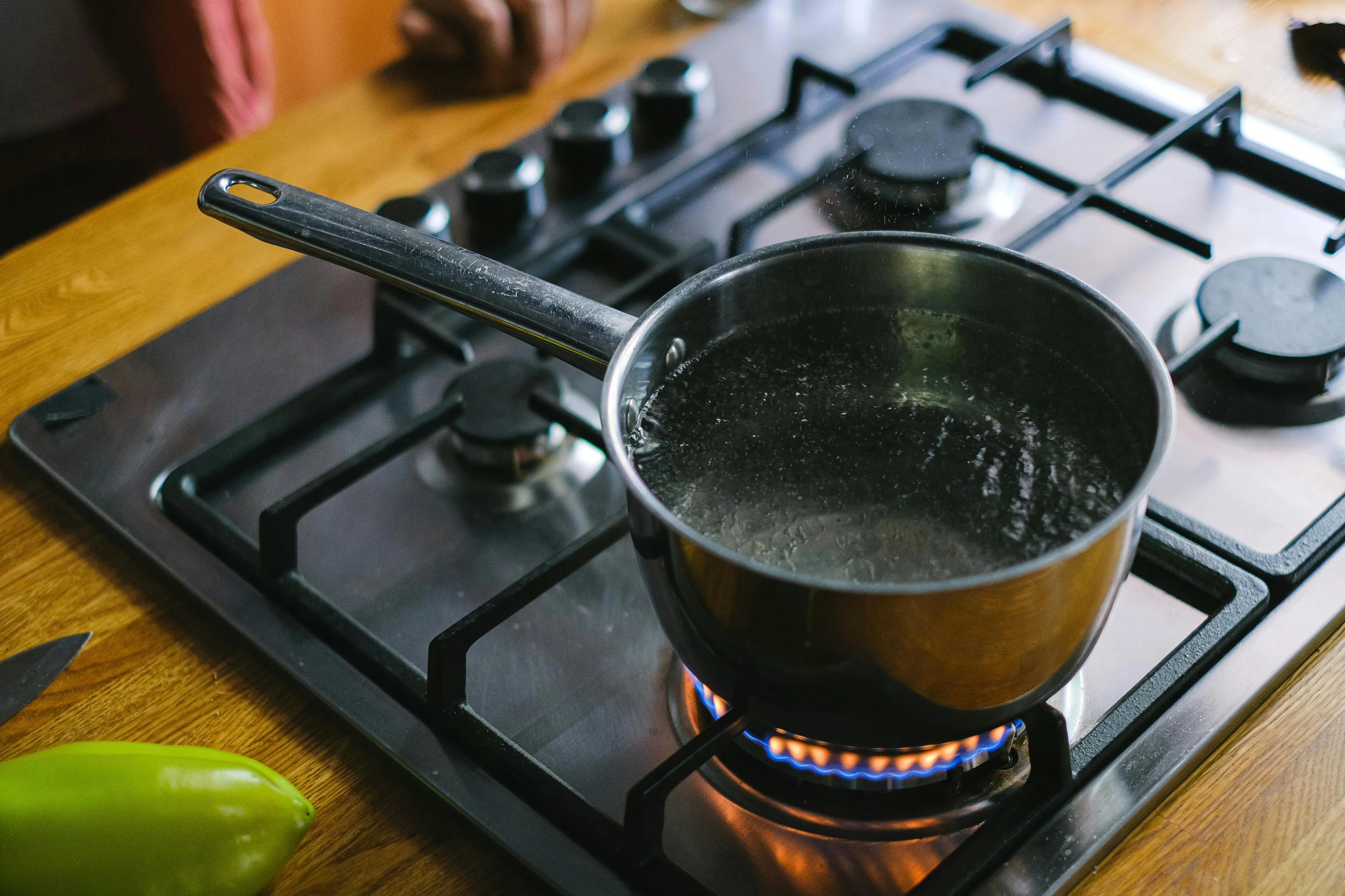 Boiling water in a pot on a gas stove illustrating the transfer of heat through the movement of fluids convection.