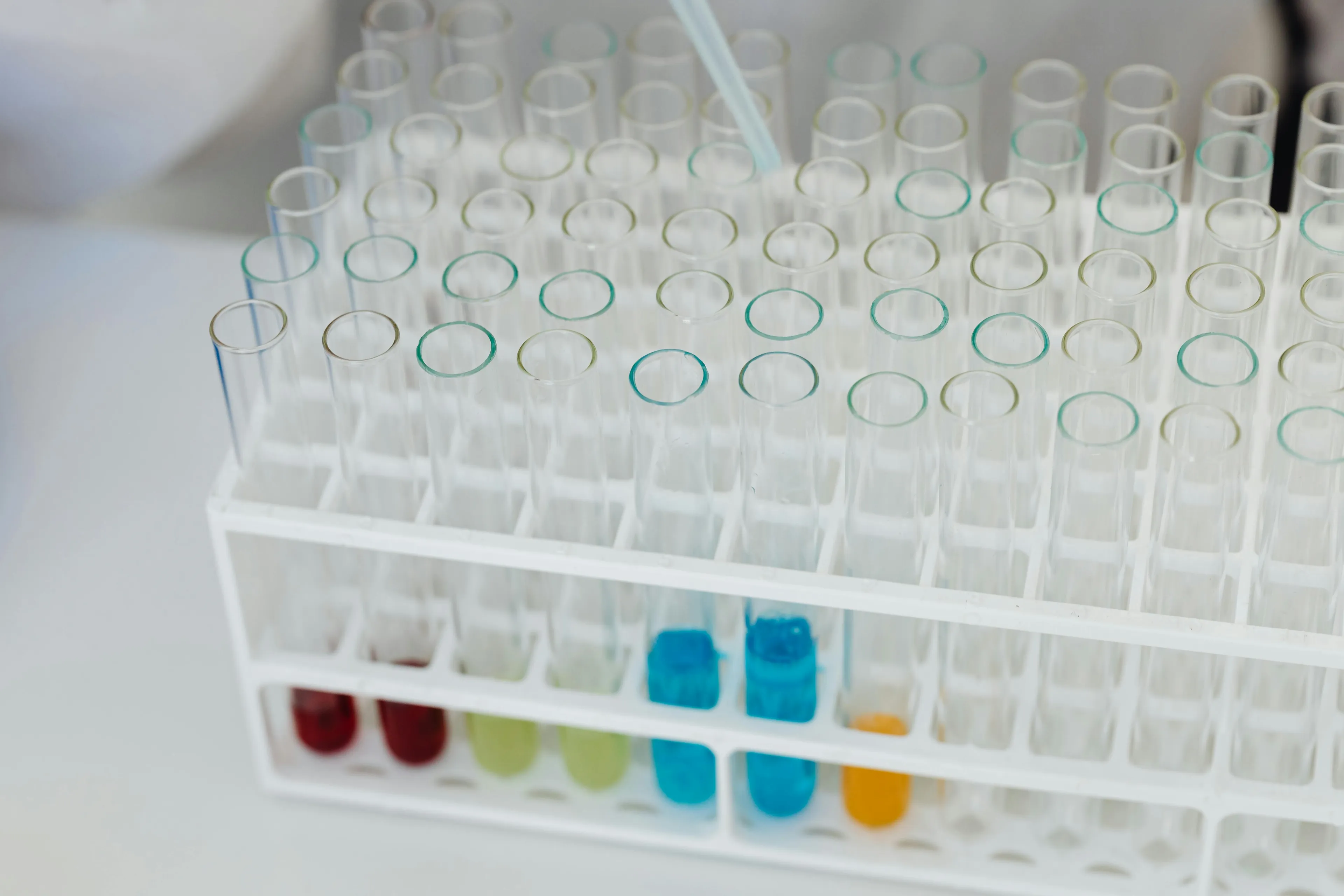 Test tubes in a laboratory rack containing various colored solutions, illustrating science general knowledge on pH buffering.