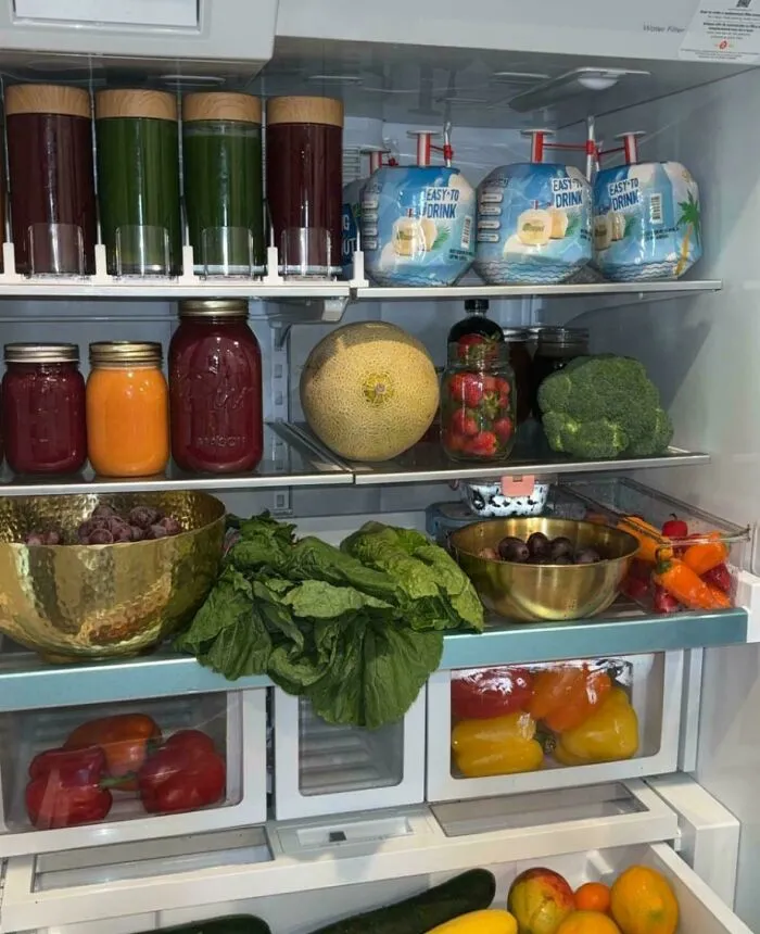 Organized fridge with fresh fruits, vegetables, and drinks showing what people found horrifying inside refrigerators.