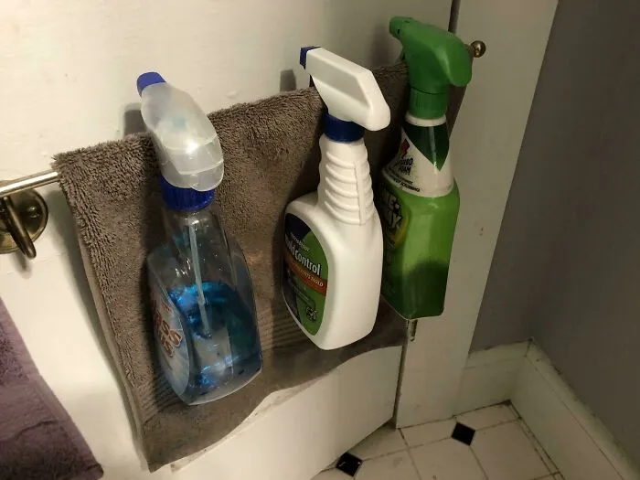 Cleaning spray bottles hanging on a towel, showcasing creative examples of if it's stupid but it works then it's not stupid.
