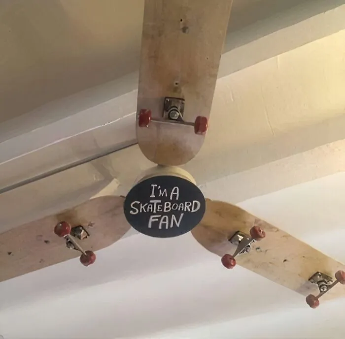 Ceiling fan made from skateboard decks with handwritten sign reading I'm a skateboard fan, showing creative example of if it's stupid but it works.