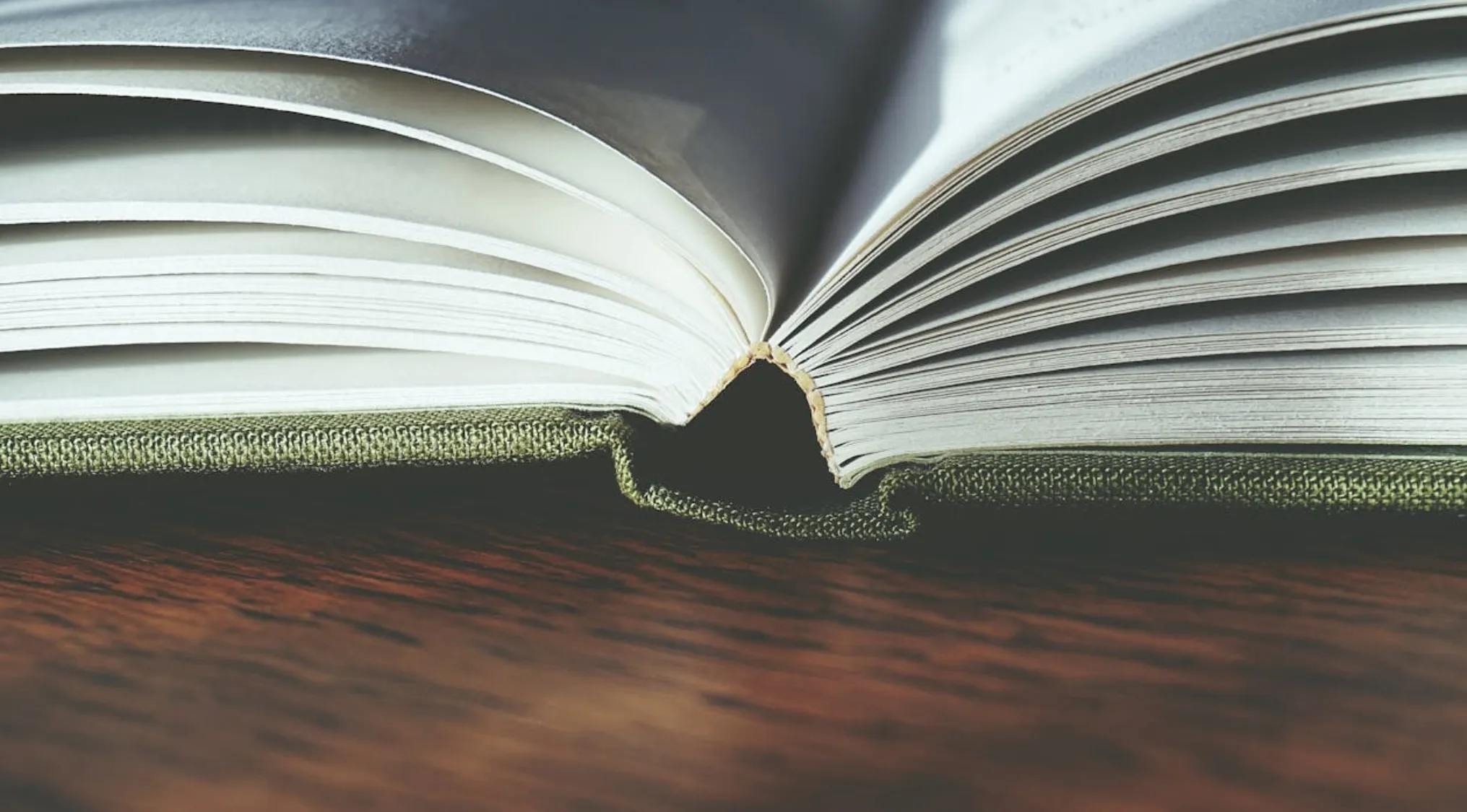 Close-up of an open book on a wooden surface illustrating basic math skills with pages partially turned.