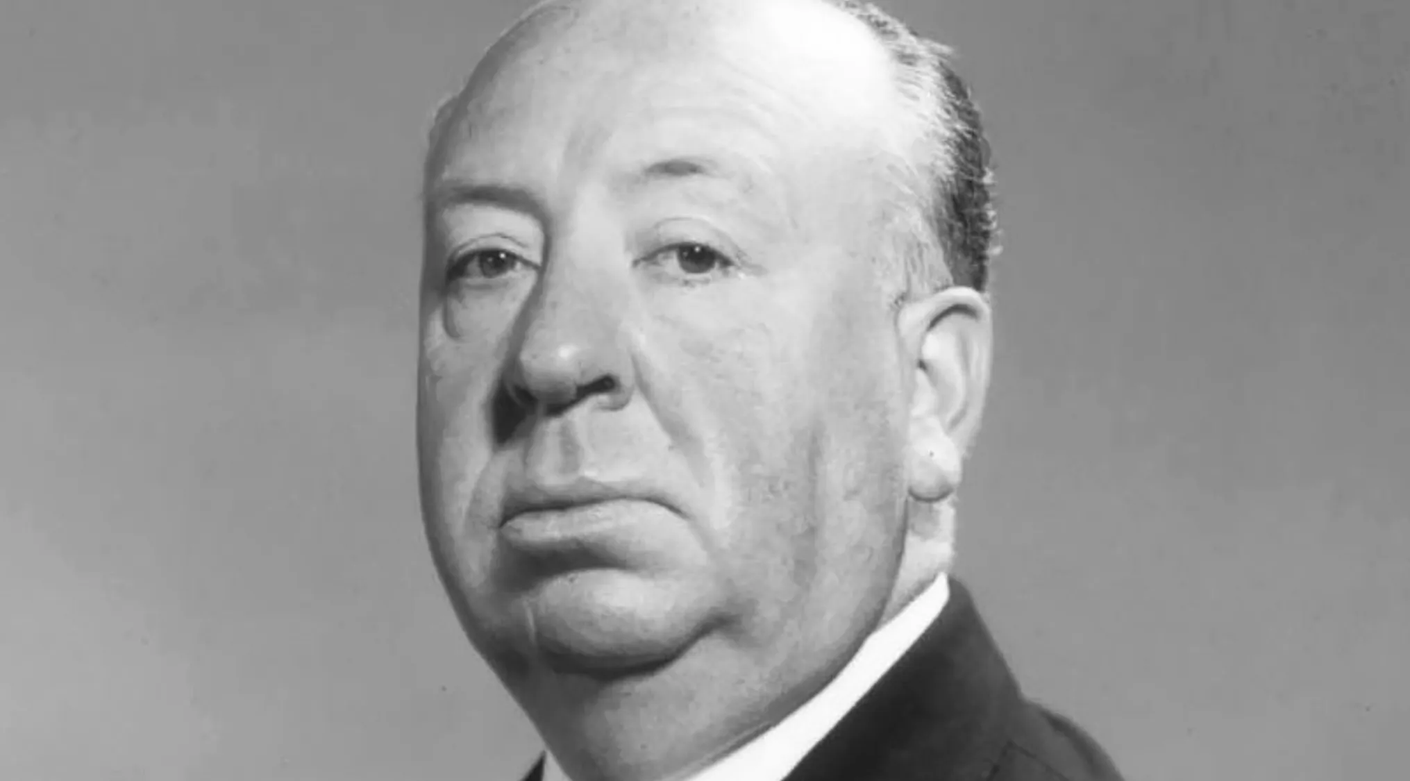 Black and white portrait of Alfred Hitchcock, director of the 1946 thriller and classic movie quiz subject.