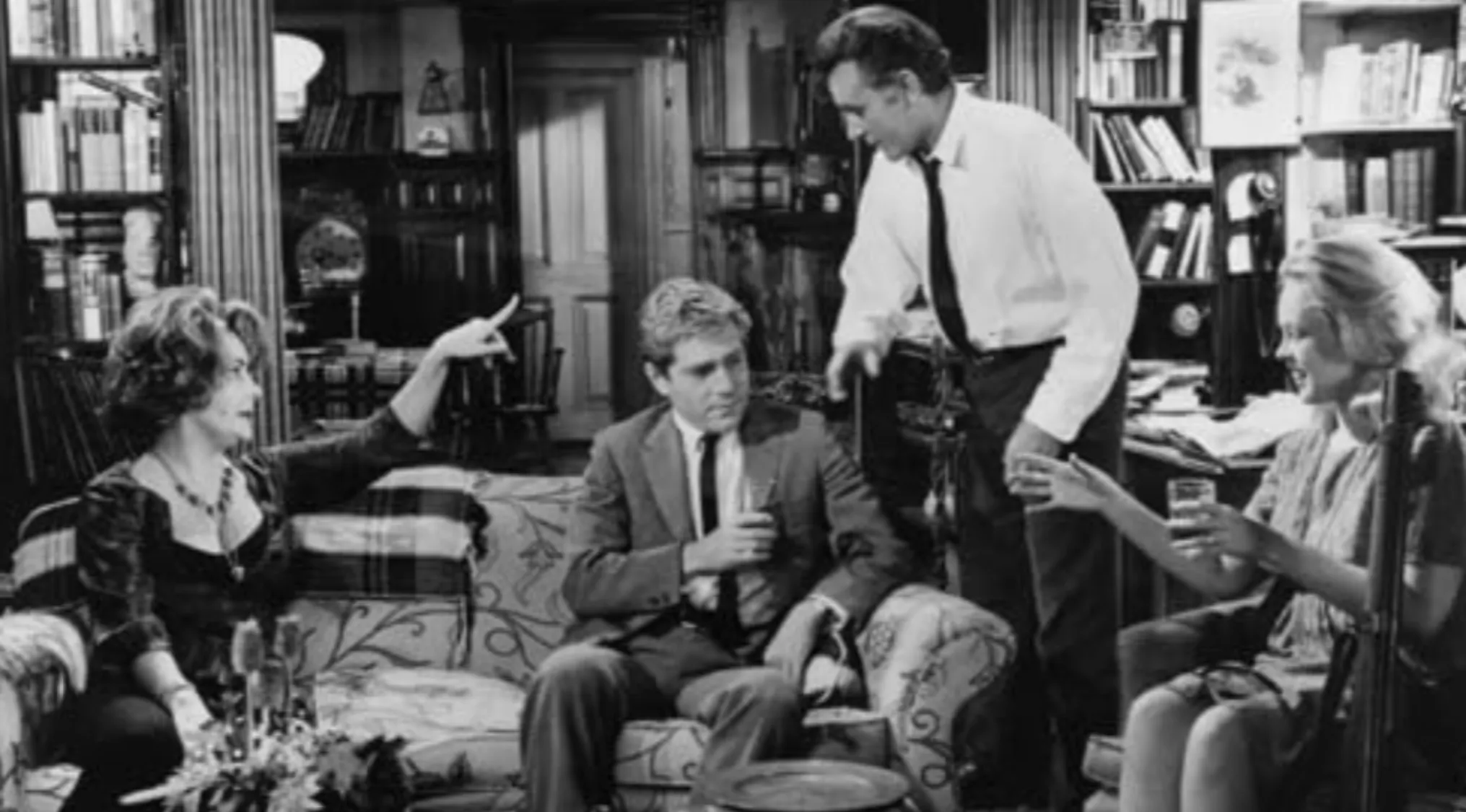 Black and white scene from 1966 drama showing emotional warfare between a married couple in a tense living room setting.