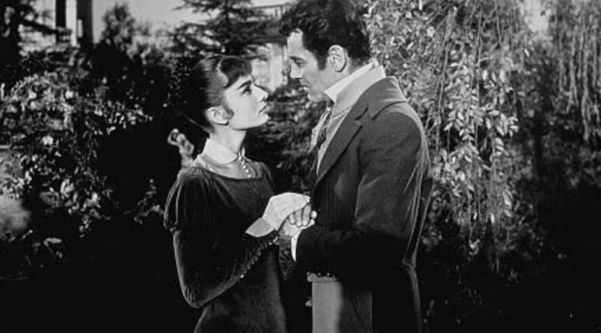 Black and white scene of actors holding hands and gazing in a classic movie quiz featuring iconic character roles.
