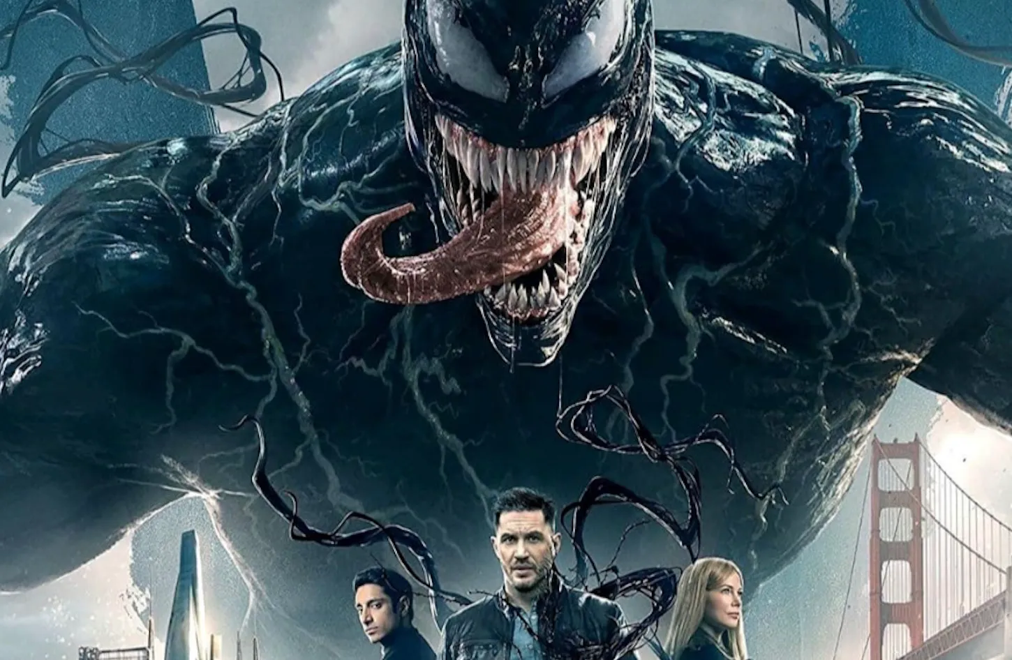 Venom with sharp teeth and long tongue looming over characters in an urban setting near a bridge at dusk.
