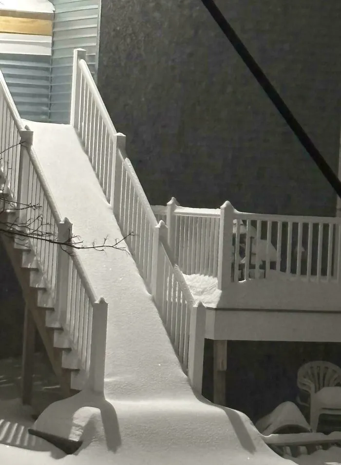 Snowstorm covered outdoor stairs and deck in deep snow during a heavy snowstorm hitting the U.S. at night.