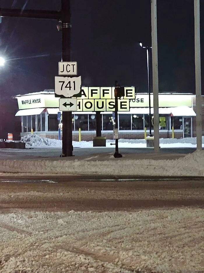 Snowstorm hitting the U.S. with heavy snow covering streets and a Waffle House lit up at night.
