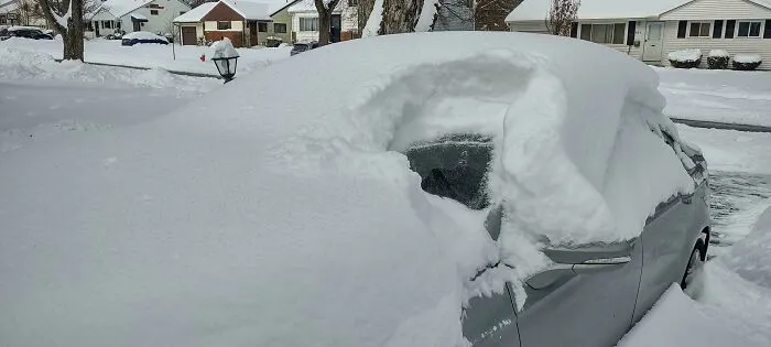 Car covered in thick snow during a heavy snowstorm hitting a residential neighborhood in the U.S.