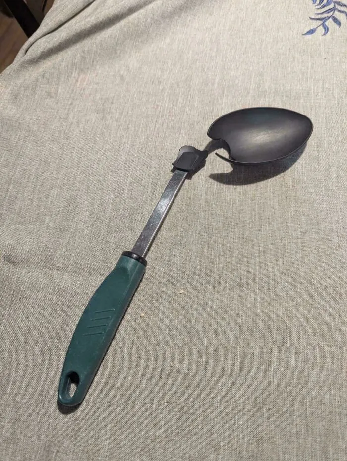 Broken kitchen spoon with a cracked handle and damaged bowl, illustrating poor consumerism and product quality.