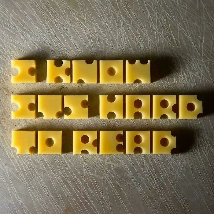 Cheese pieces arranged to spell message on cutting board