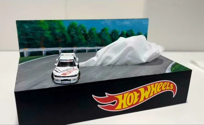 Hot Wheels toy car driving on a detailed miniature road diorama