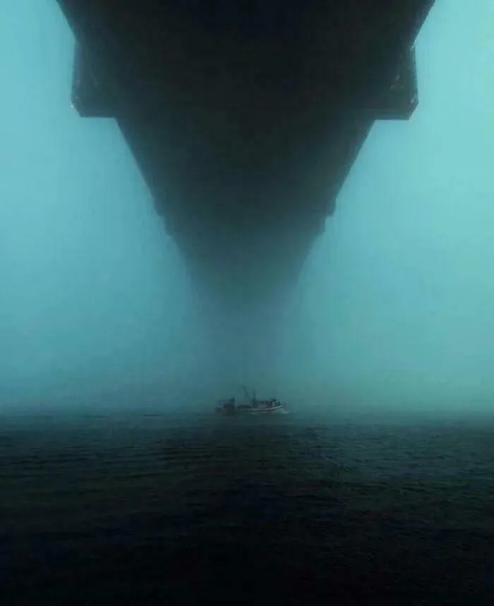 A Boat Under A Large Bridge