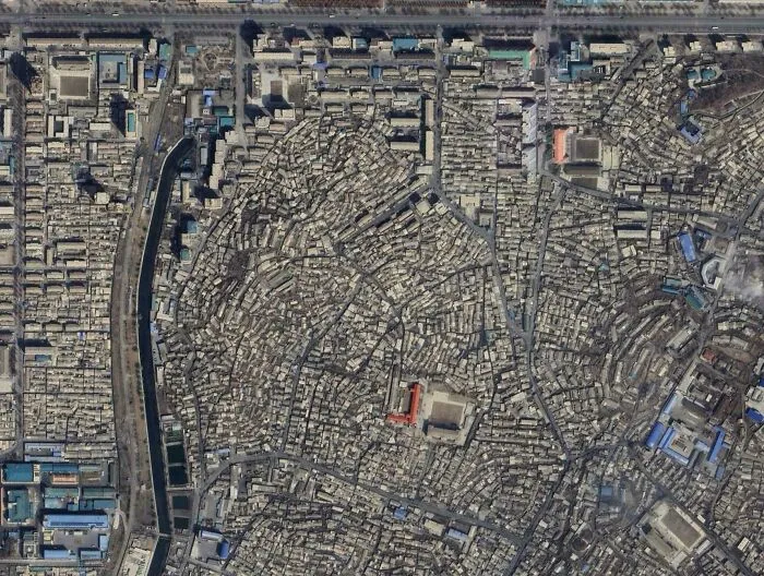 Aerial view of dense urban hell showing the crowded, chaotic layout of a dystopian modern cityscape.