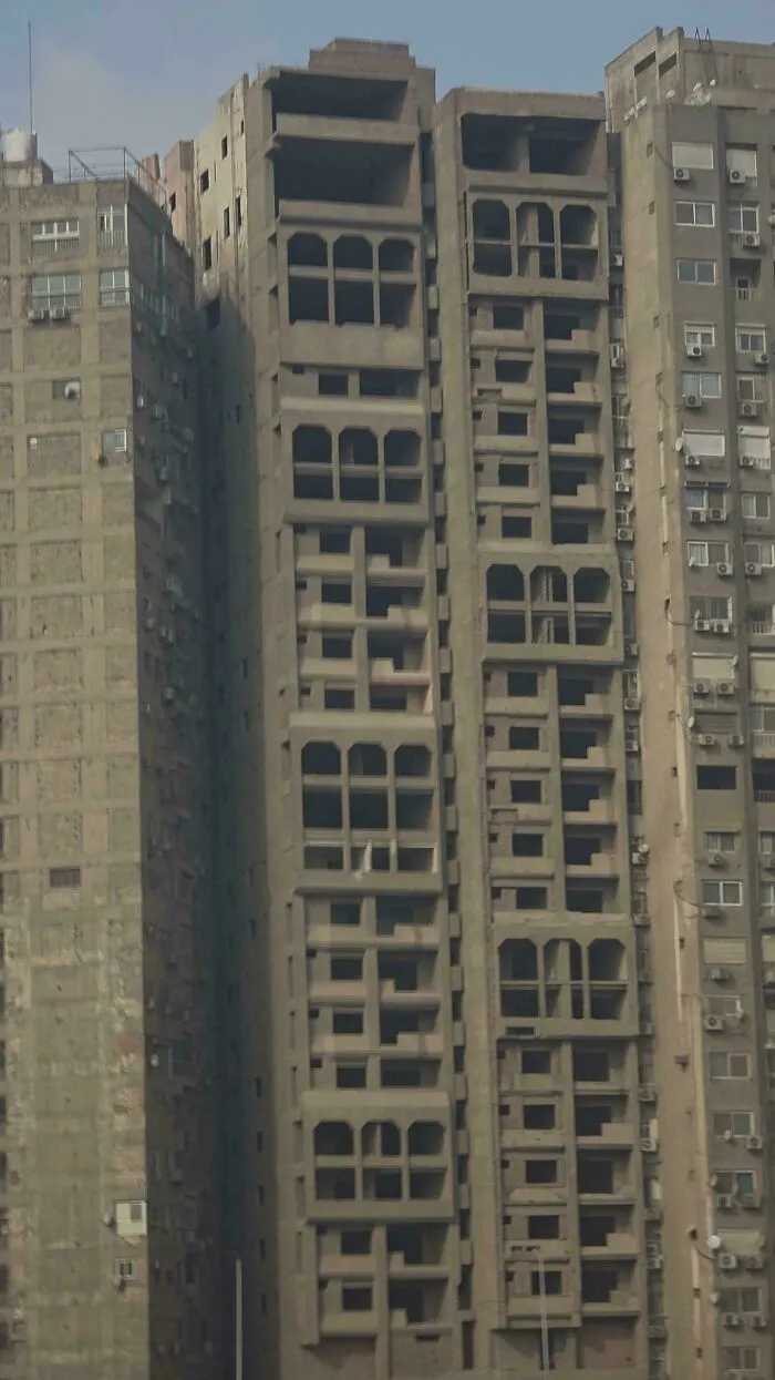 Dystopian urban hell scene showing tightly packed abandoned apartment buildings symbolizing the true price of modern life.