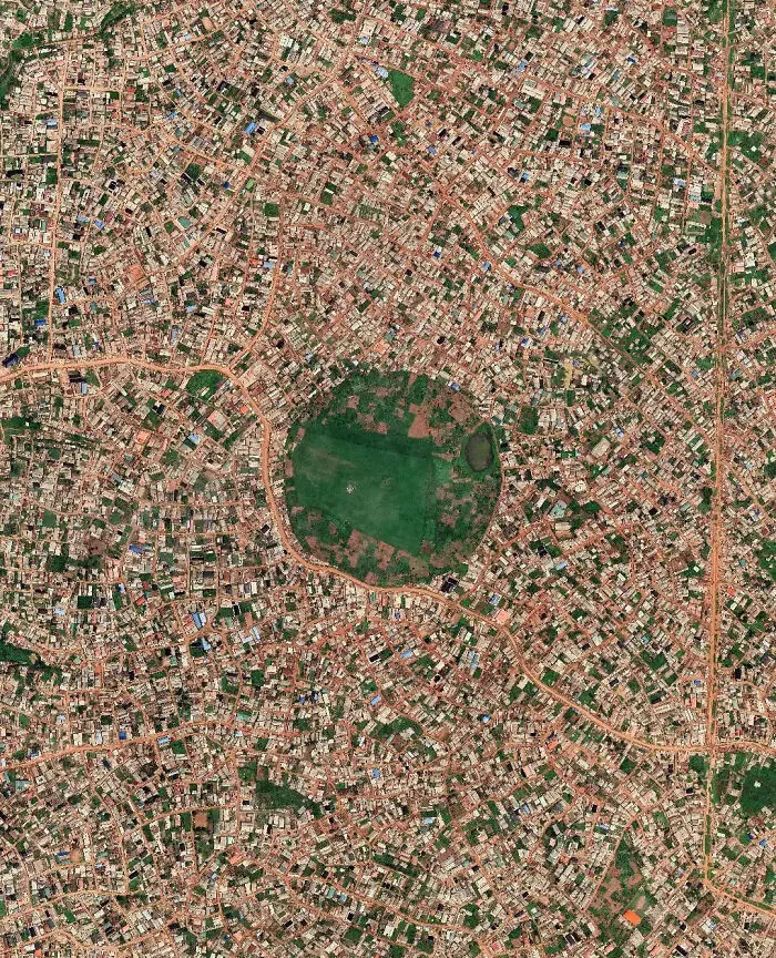 Aerial view of dense urban sprawl with limited green space depicting a dystopian urban hell cityscape.