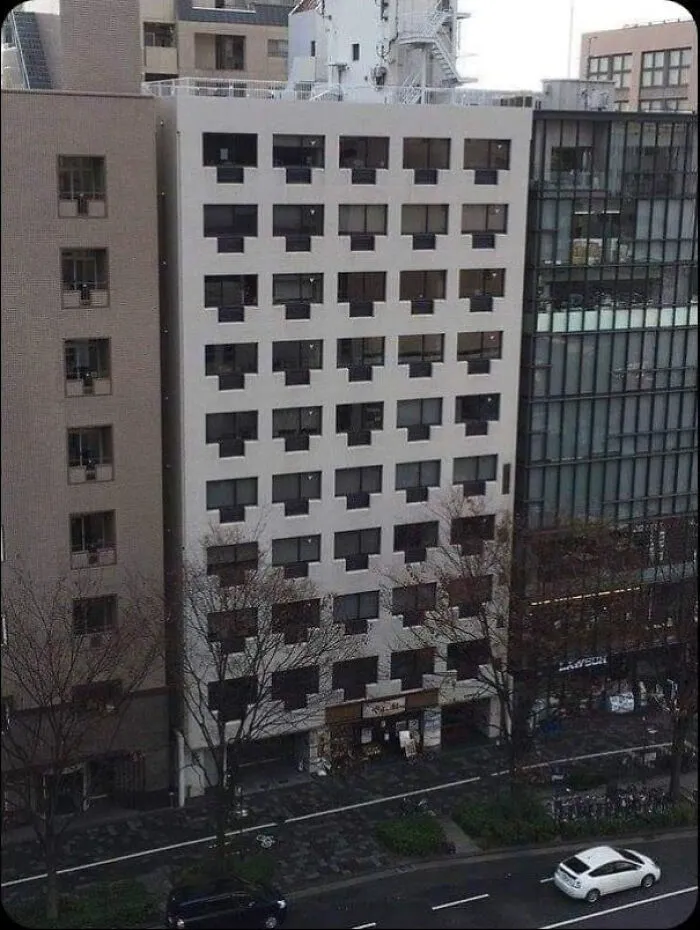 Dystopian urban hell building with repetitive window design on a city street, highlighting the true price of modern life.