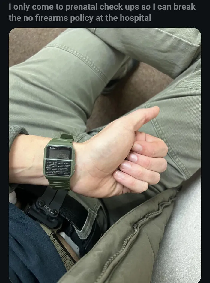 Man wearing green watch showing thumb up and concealed carrying firearm at hospital prenatal appointment