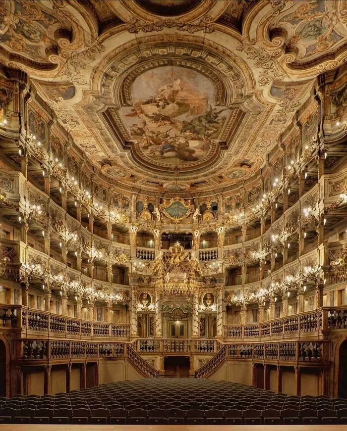 Beautiful architecture of a grand theater with multiple tiers, intricate gold decorations, and a painted ceiling.