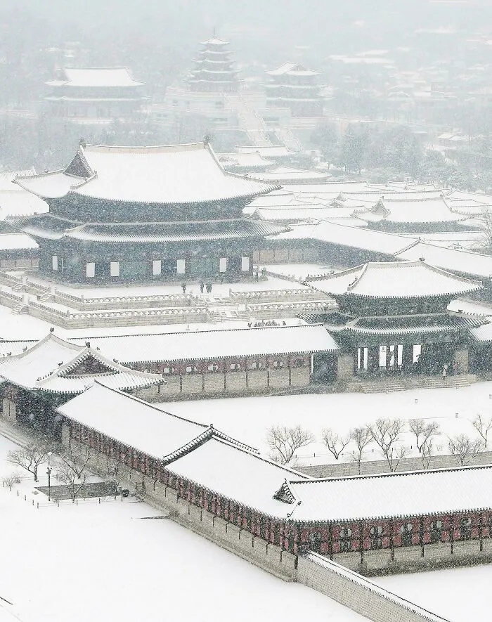 Beautiful architecture: A majestic traditional palace complex covered in snow, creating a serene and picturesque winter scene.
