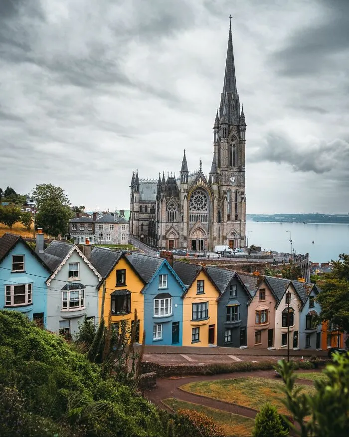 Beautiful architecture: A grand cathedral towering over a row of colorful houses by the water.