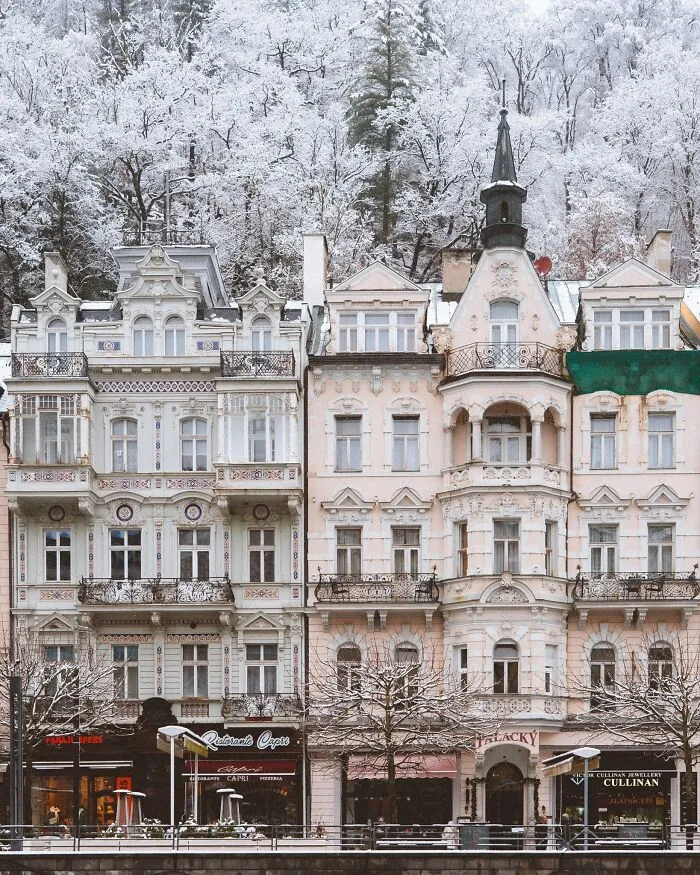 Charming European architecture with ornate balconies and intricate details, covered in a picturesque layer of snow.