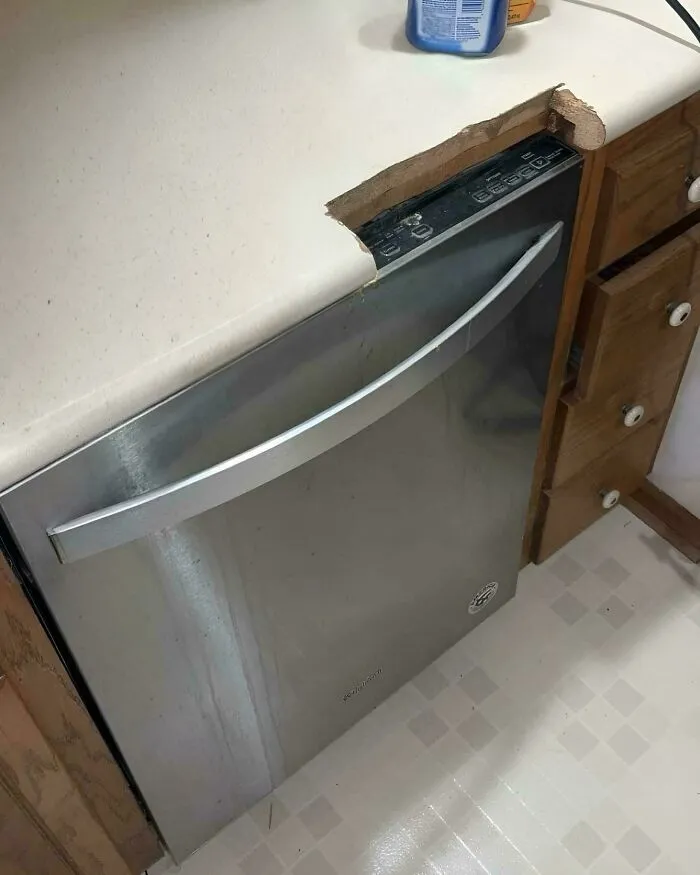 Dishwasher installed with rough cut countertop edge, an example of redneck engineering in a kitchen setting.