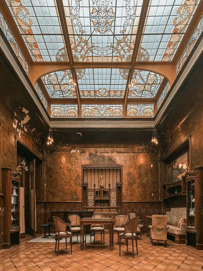 An interior view of a room with a stunning stained-glass ceiling and rich, textured walls, exemplifying beautiful architecture.