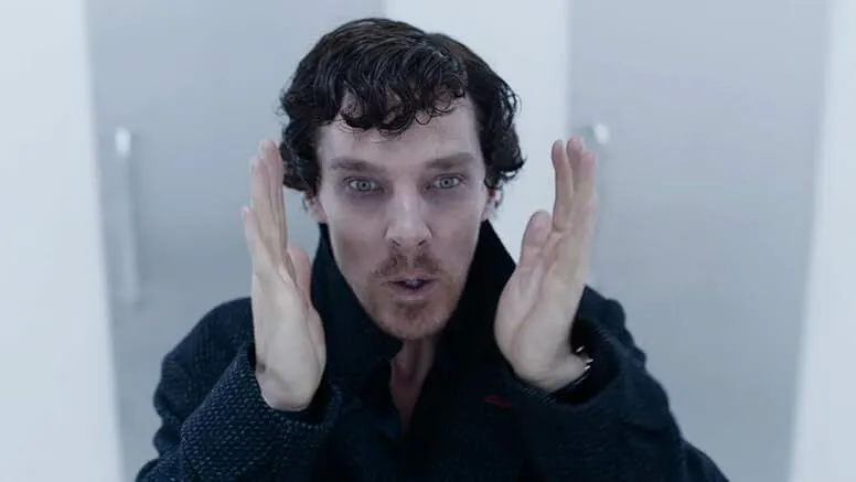 Benedict Cumberbatch in a dark coat portraying an iconic detective in a modern TV show scene with intense expression.