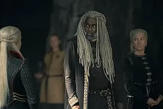 Scene from House of the Dragon featuring three characters in medieval attire in a dimly lit hall.