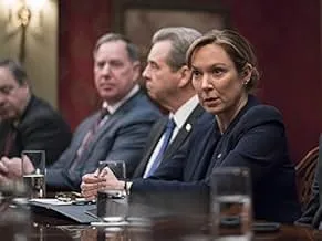 Group of serious professionals in a formal meeting discussing strategic matters in a dimly lit room.