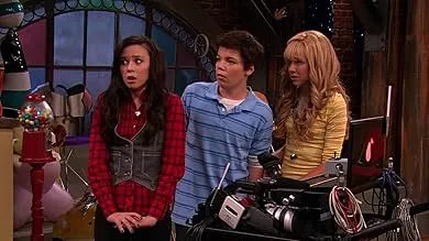 Three teenagers in a studio setting with camera equipment, discussing a scene from the iCarly drama series.
