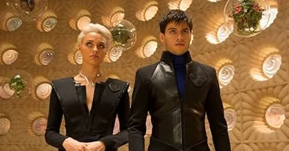 Two characters from Krypton in futuristic outfits, standing in an ornate room, hinting at a spy thriller cat-and-mouse chase.