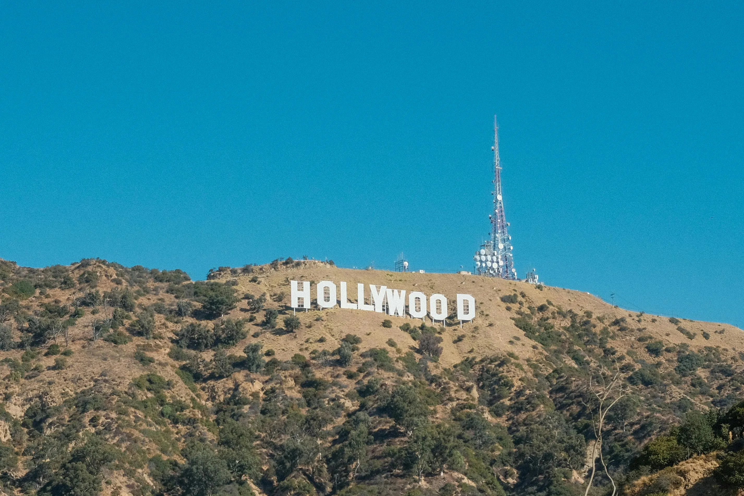 Hollywood sign on sunny hill with clear blue sky representing TV shows character leaving Hell to run a nightclub in Los Angeles