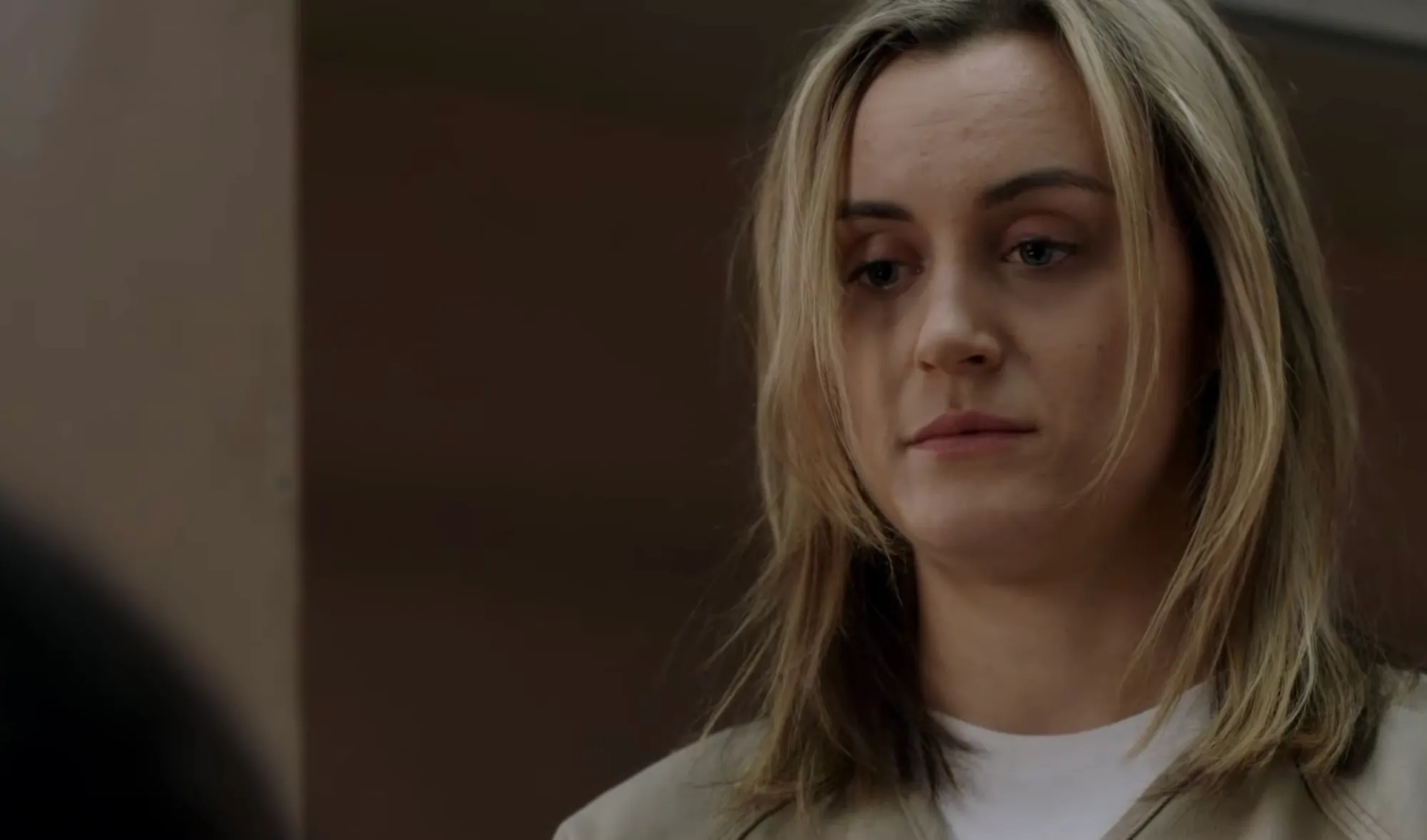 Woman with blonde hair and neutral expression in a beige outfit, related to character receptionist and office administrator The Office.