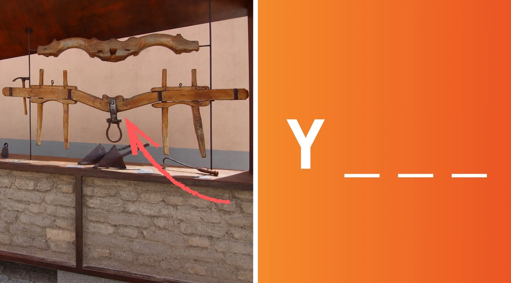 Yoke tool made of wood with iron ring, displayed in an outdoor exhibit with wooden plow tools nearby.