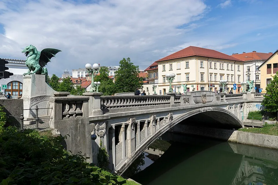 Dragon Bridge with dragon statues over river in an urban setting, a popular landmark for guessing countries.